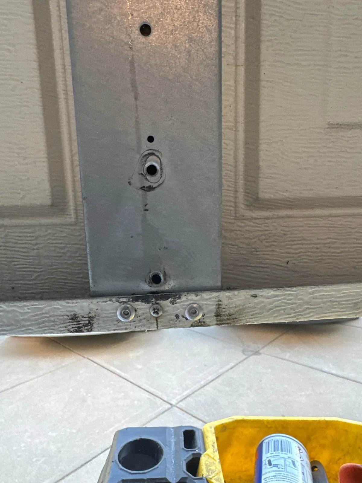 Repaired garage door bottom bracket secured to the panel in Fremont.