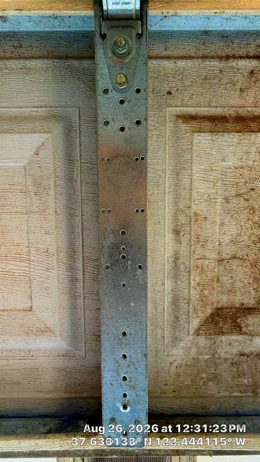 Repaired center stile secured to the same bottom garage door section.